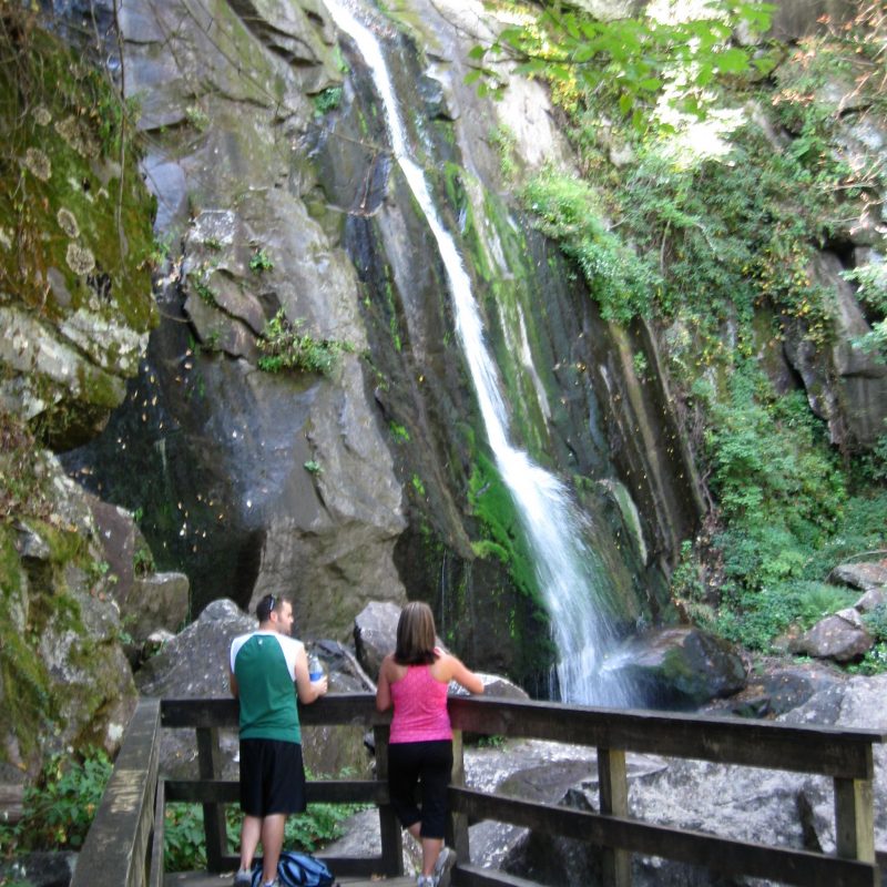 Man and woman on viewing platform at base of High Shoals Falls in South Mountains State Park, Connelly Springs, North Carolina