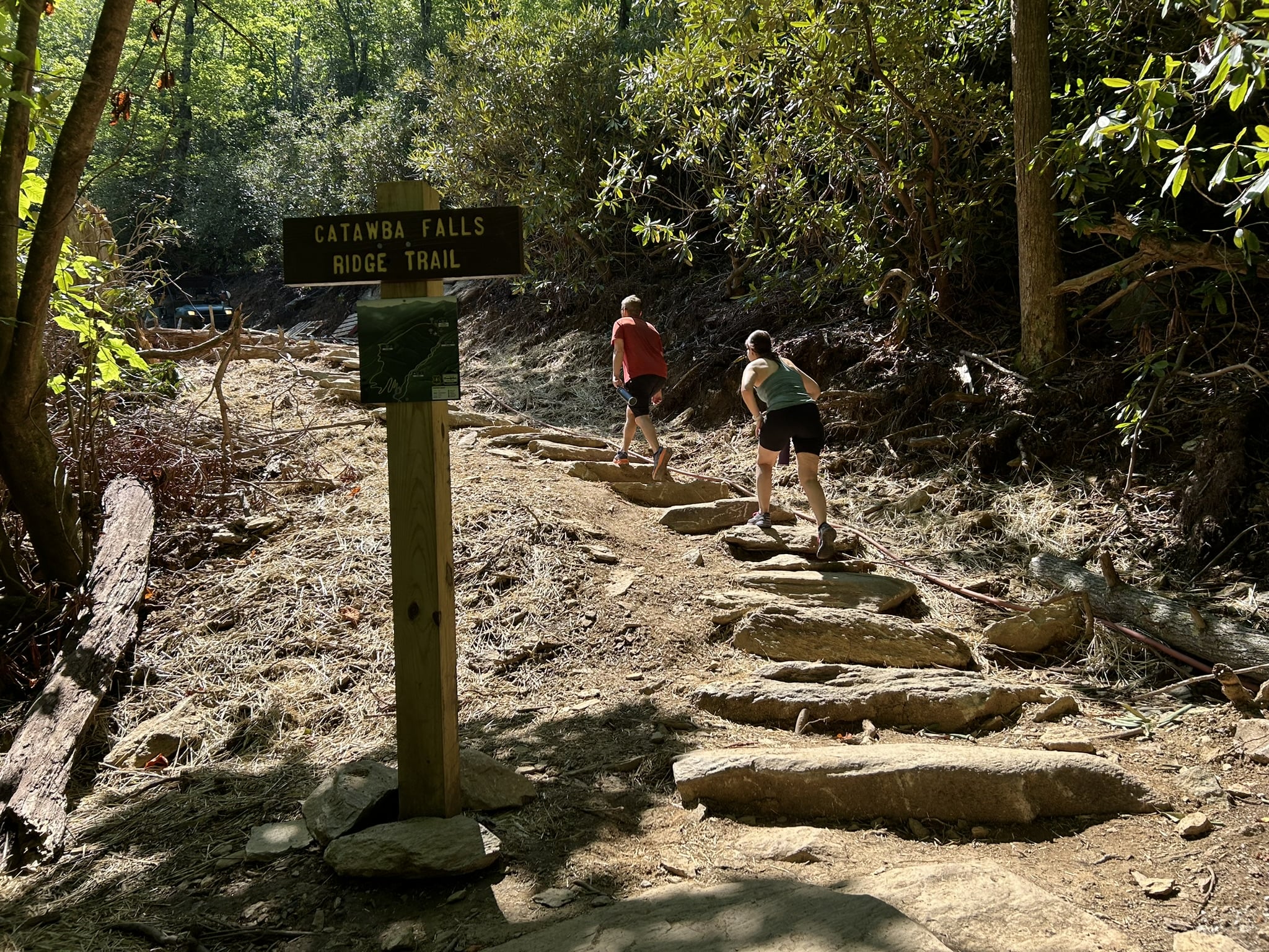 trail sign and hikers on mountain ridge