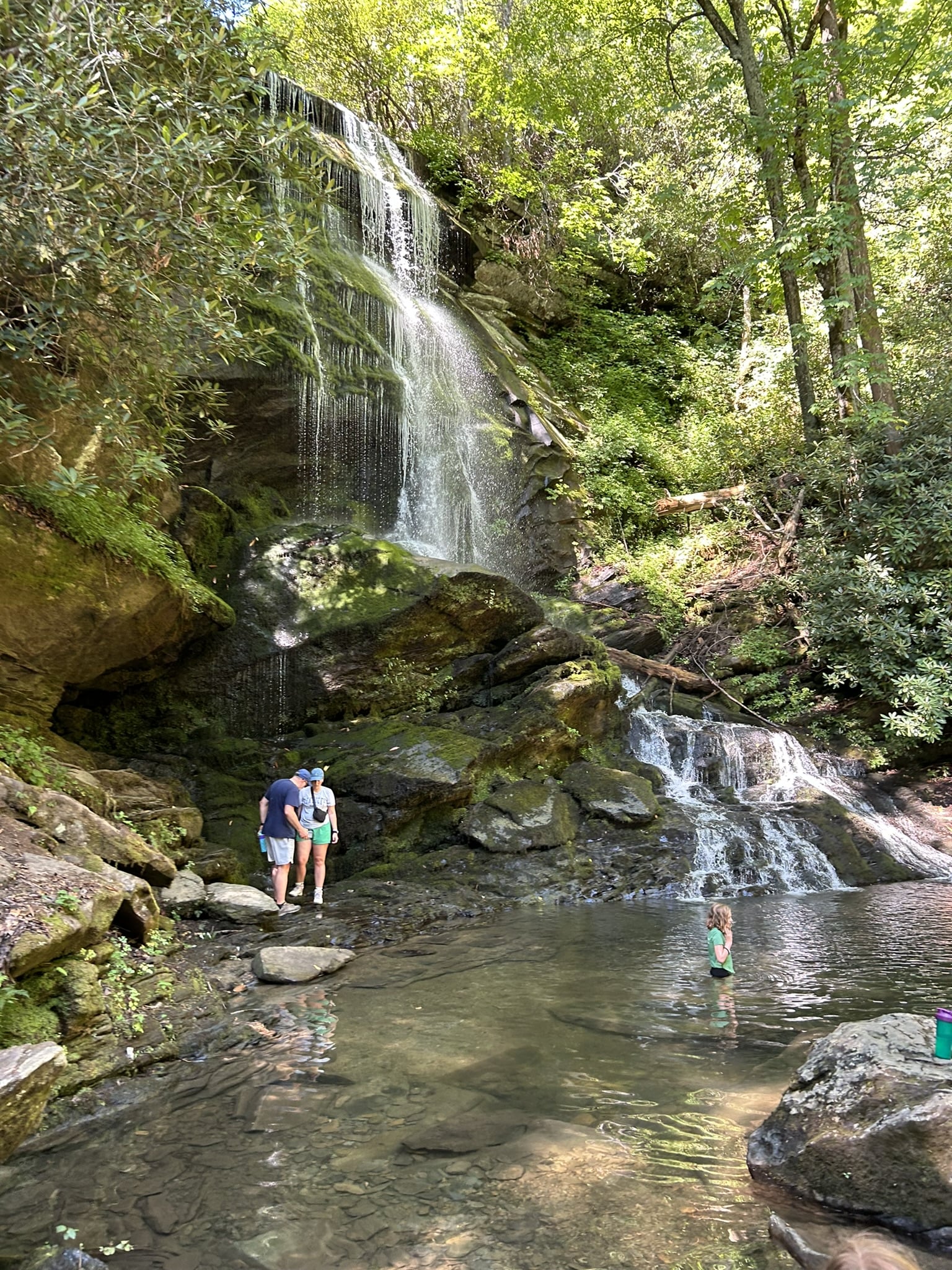 family at base of waterfall in forest